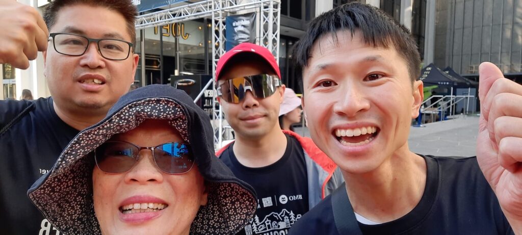 People looking happy after a marathon with their thumbs up.