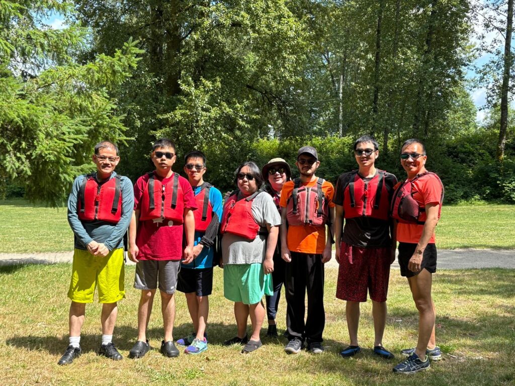 Group of people looking happy wearing life jackets.