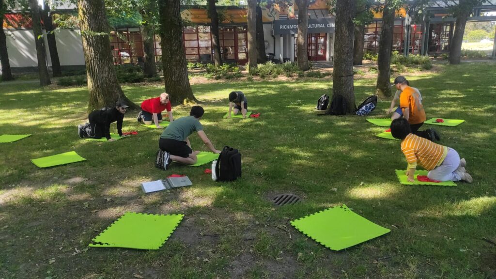 Information & Networking. People stretching in front of the Richmond Cultural Centre.