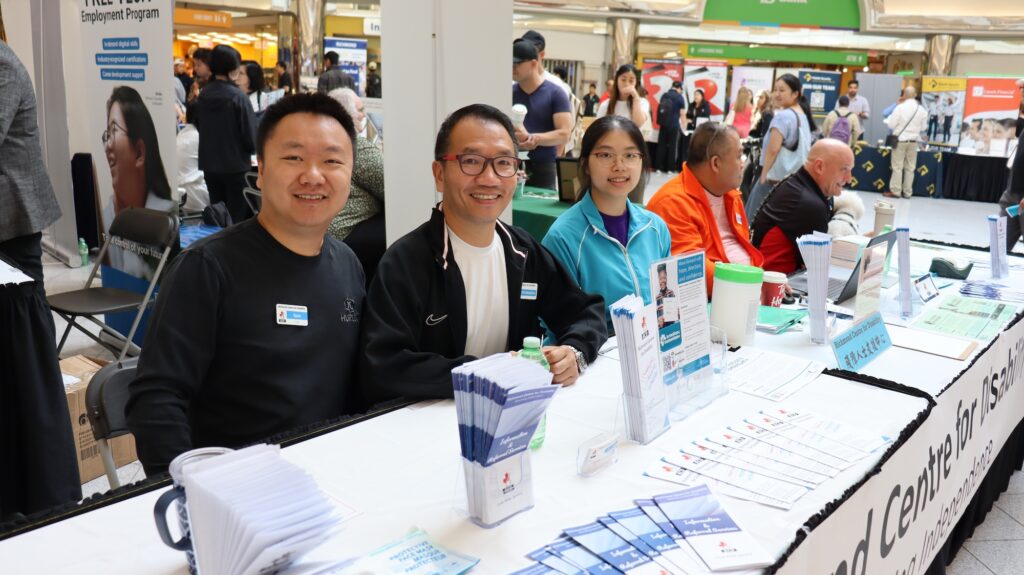 Homepage image to represent publications. People sitting together at the information booth representing Richmond Centre for Disability.